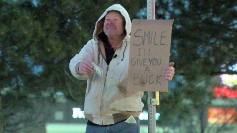 PHOTO: A man in Parker, Colo., gives out dollars for smiles on Dec. 28, 2015 in memory of Carl Ramsey, a high school friend of his who passed away at age 18.