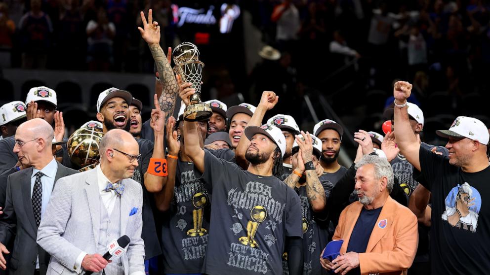 PHOTO: Jalen Brunson of the New York Knicks lifts the Bill Russell NBA Finals Most Valuable Player Award trophy after defeating the San Antonio Spurs in Game Five of the 2026 NBA Finals, June 13, 2026 in San Antonio.