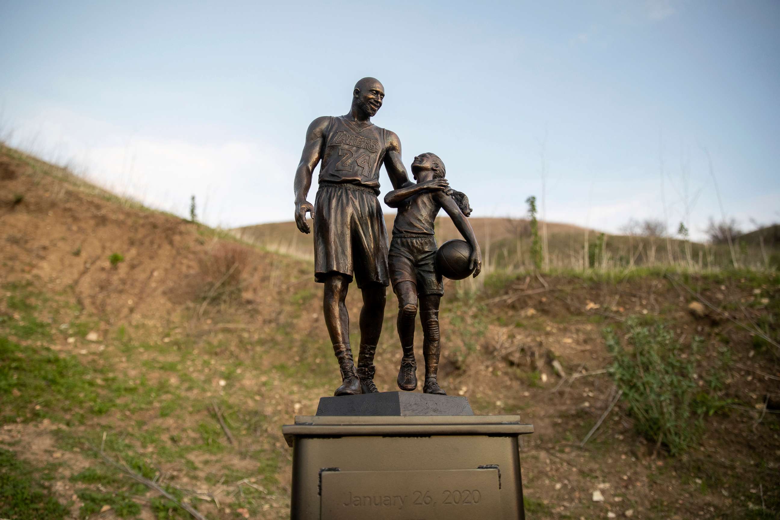 PHOTO: In this Jan. 26, 2022, file photo, artist Dan Medina's bronze sculpture depicting Kobe Bryant, daughter Gianna Bryant, and the names of those who died in a helicopter crash in 2020, is seen during a temporary memorial display in Calabasas, Calif.