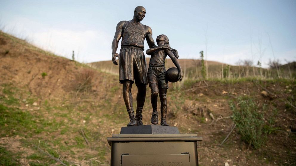 PHOTO: In this Jan. 26, 2022, file photo, artist Dan Medina's bronze sculpture depicting Kobe Bryant, daughter Gianna Bryant, and the names of those who died in a helicopter crash in 2020, is seen during a temporary memorial display in Calabasas, Calif.