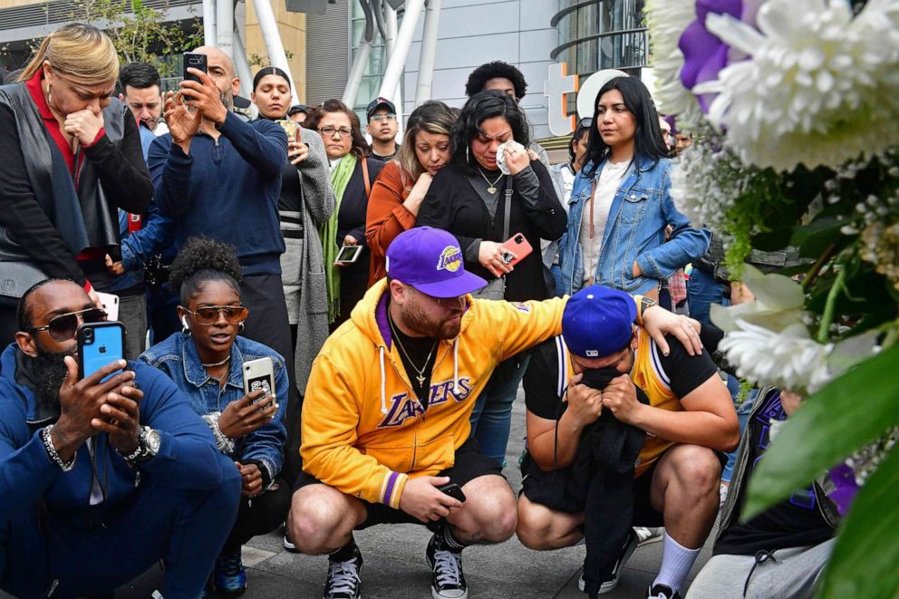 PHOTO:People gather around a makeshift memorial for former NBA and Los Angeles Lakers player Kobe Bryant after learning of his death at LA Live plaza in front of Staples Center in Los Angeles, Jan. 26, 2020.