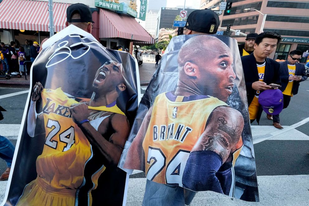 PHOTO: Fans carry posters of Kobe Bryant near the Staples Center before a public memorial for former Los Angeles Lakers star Kobe Bryant and his daughter, Gianna, in Los Angeles, Feb. 24, 2020.
