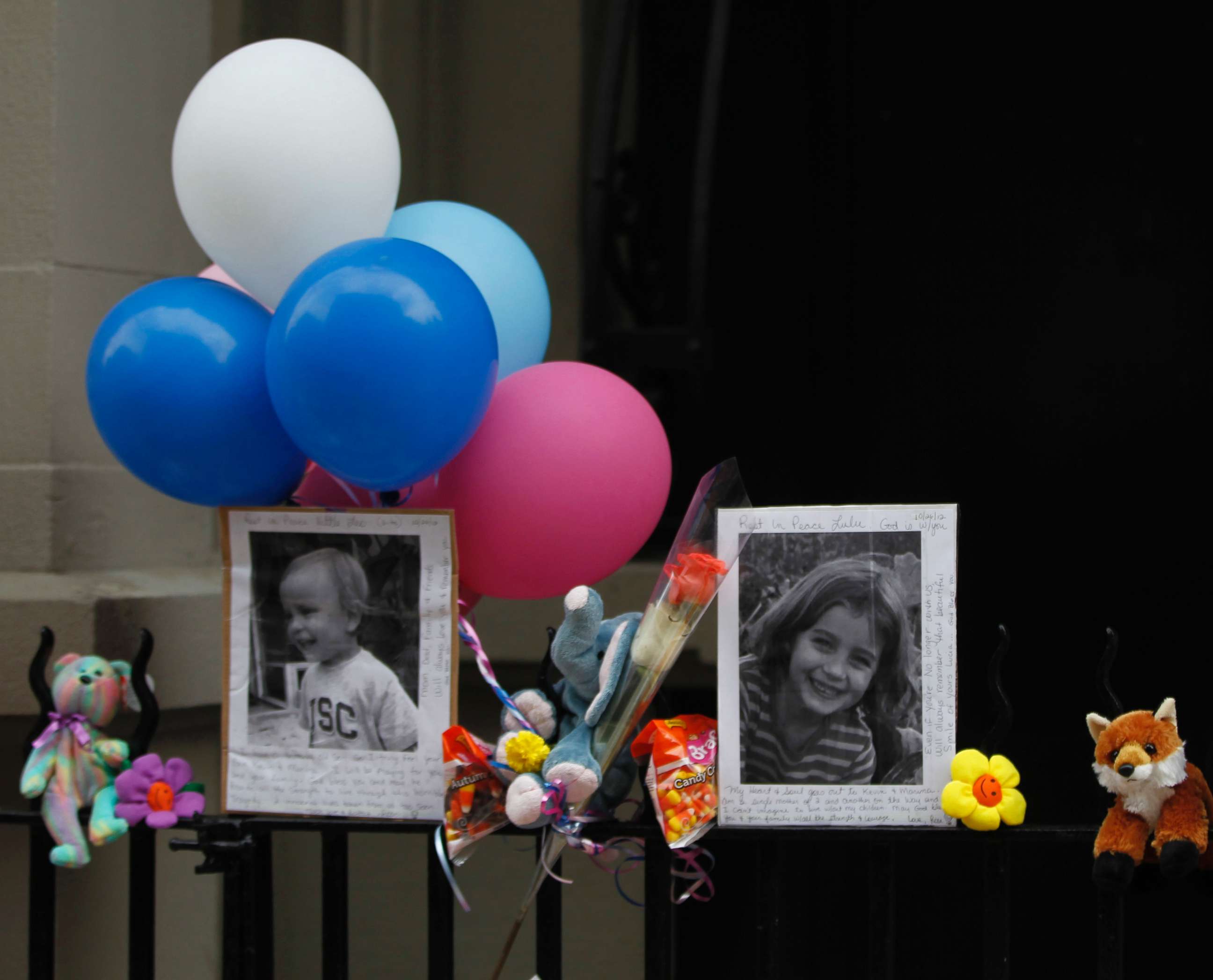 PHOTO: Photographs of the two children stabbed by their nanny are displayed alongside balloons and stuffed animals at a memorial outside the apartment building were they lived in New York City, Oct. 27, 2012.