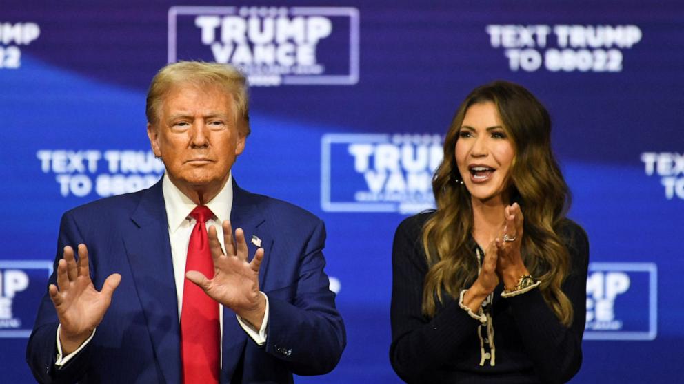 PHOTO: Republican presidential nominee former President Donald Trump stands next to South Dakota Governor Kristi Noem during a town hall campaign event in Oaks, Pennsylvania, Oct. 14, 2024.  