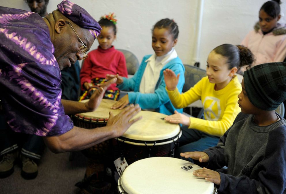 PHOTO: Dwight Baldwin gives African drumming pointers to children during Kwanzaa observances at Kente Cultural Center in New London, Conn., Dec. 27, 2012.