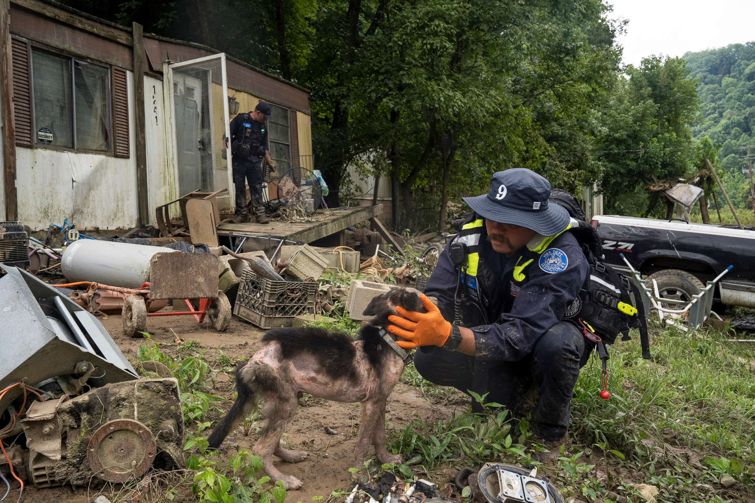PHOTO: A firefighter from the Lexington Fire Department Search and Rescue team checks on a dog during a targeted search on Highway 476 where three people are still unaccounted for, July 31, 2022, near Jackson, Ky.