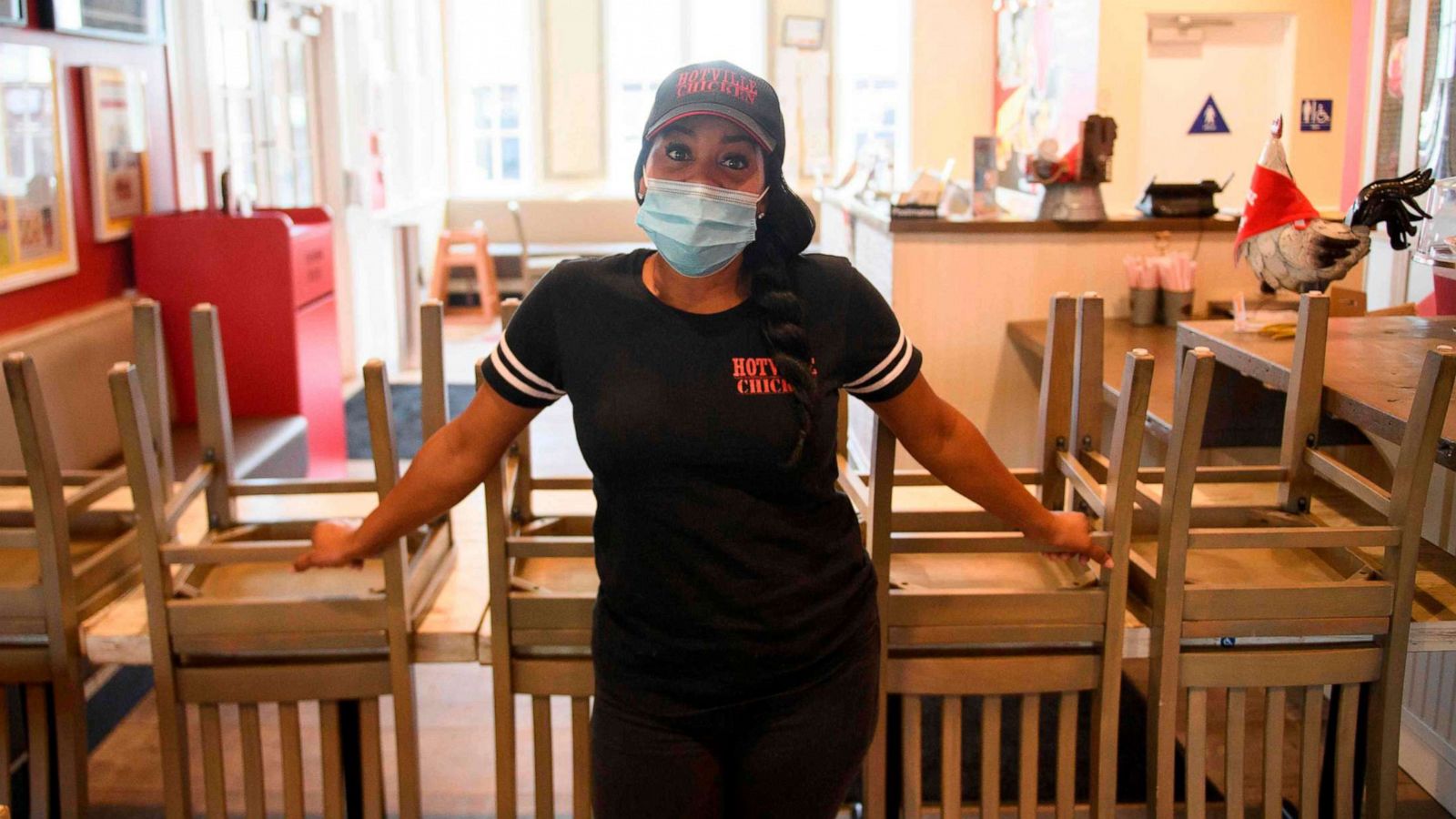 PHOTO: Kim Prince, owner of the Hotville Chicken, stands for a portrait with tables and chairs from the closed indoor dining area of her restaurant at Baldwin Hills Crenshaw in Los Angeles, Nov. 24, 2020.