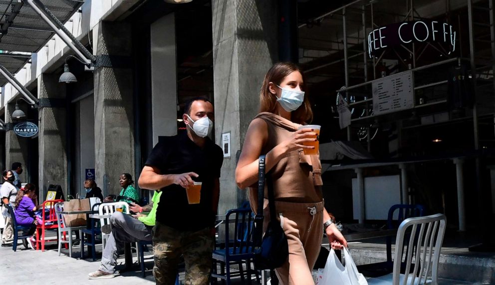 PHOTO: People carry their pints of beer past tables for outdoor dining in Los Angeles on July 1, 2020, after indoor restaurants, bars and movie theaters across much of California were ordered to close for at least three weeks.