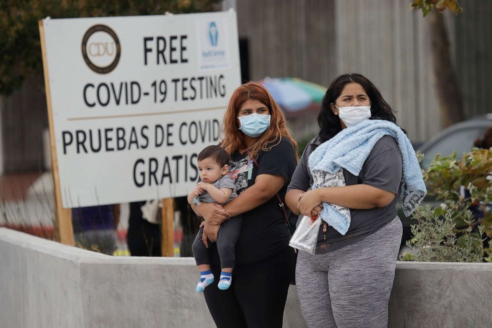 PHOTO: Two women and a child wait to take a coronavirus test at a mobile testing site at the Charles Drew University of Medicine and Science Wednesday, July 22, 2020, in Los Angeles.