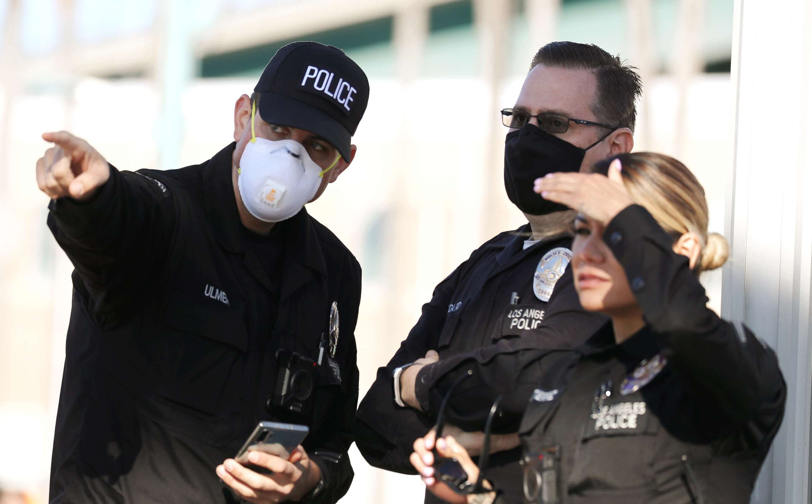 PHOTO: LAPD officers, some wearing masks, keep watch after the USNS Mercy Navy hospital ship arrived in the Port of Los Angeles to assist with the coronavirus pandemic on March 27, 2020 in San Pedro, California. 