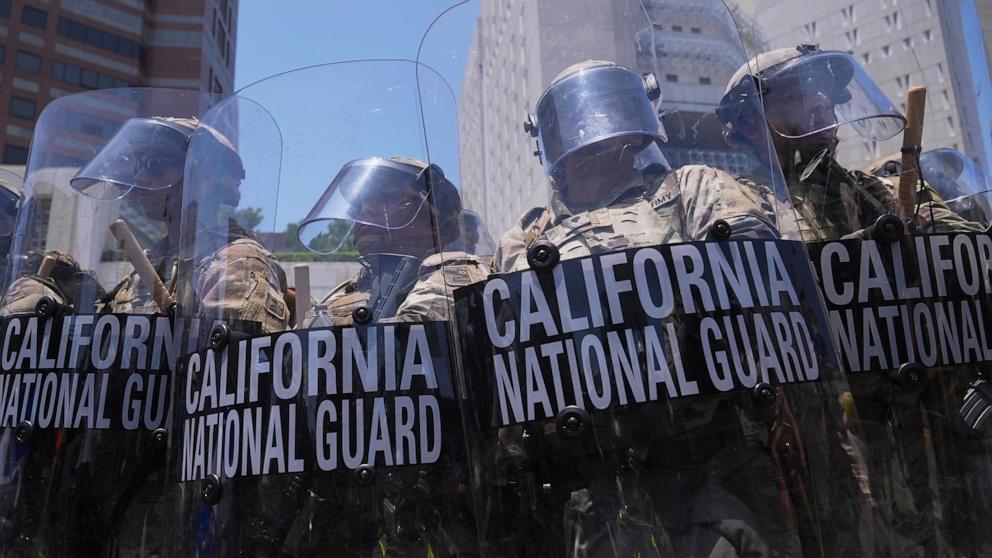 PHOTO: Members of the California national guard stand in tear gas while trying to clear protesters at the metropolitan detention center in downtown Los Angeles, June 8, 2025.