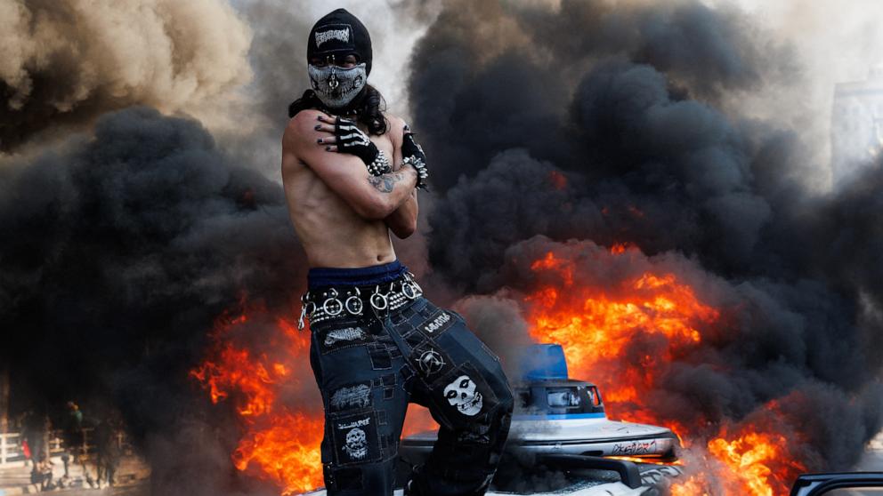 PHOTO: A protestor standing on top of a burning Waymo vehicle during demonstrations in Los Angeles, June 8, 2025.
