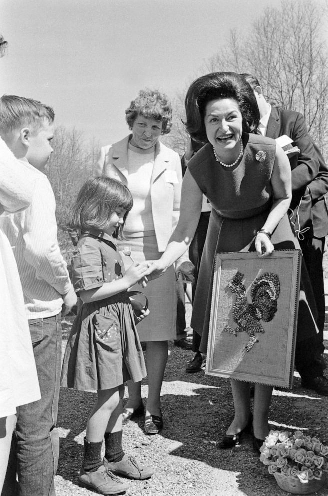 PHOTO: Lady Bird Johnson holds artwork while greeting a young girl during her tour of Appalachia in 1967.