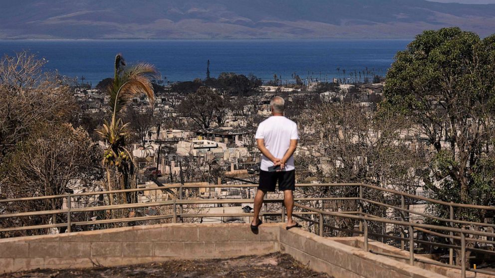 PHOTO: A man looks at burned buildings in the aftermath of the Maui wildfires in Lahaina, Hawaii on Aug. 16, 2023.