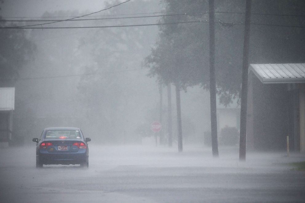 PHOTO: A car drives through heavy rainfall and street flooding as Hurricane Delta moves in, Oct. 9, 2020 in Lake Arthur, La.