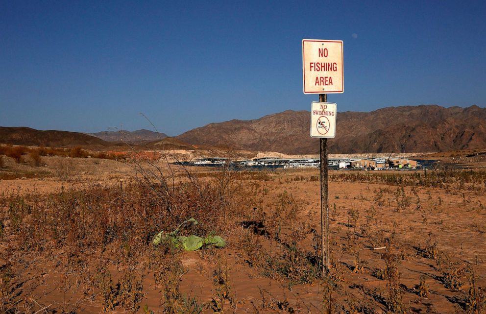 PHOTO: A "no fishing area" sign and a "no swimming" sign are posted in an area once underwater at the Callville Bay Marina, June 21, 2021, in the Lake Mead National Recreation Area, Nevada.