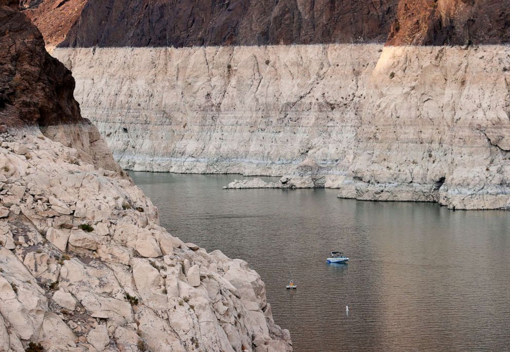 PHOTO: A boat cruises past mineral-stained rocks on the upstream side of the Hoover Dam, June 15, 2021, in the Lake Mead National Recreation Area, Nevada.