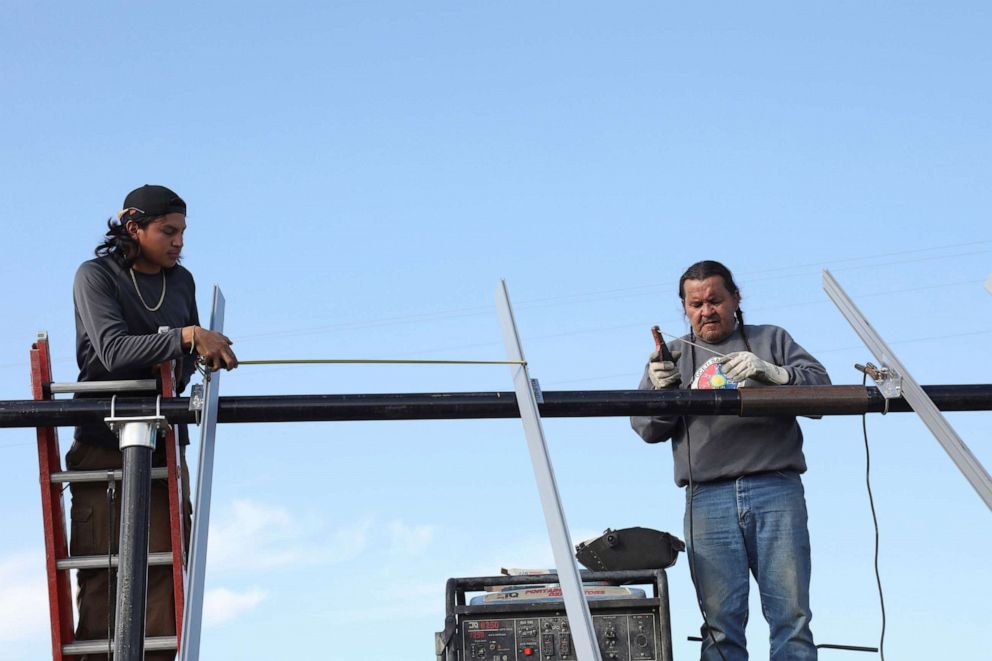 PHOTO: Darren Cross and Henry Red Cloud install solar panels on the Pine Ridge reservation in South Dakota, Sept. 24, 2018. 