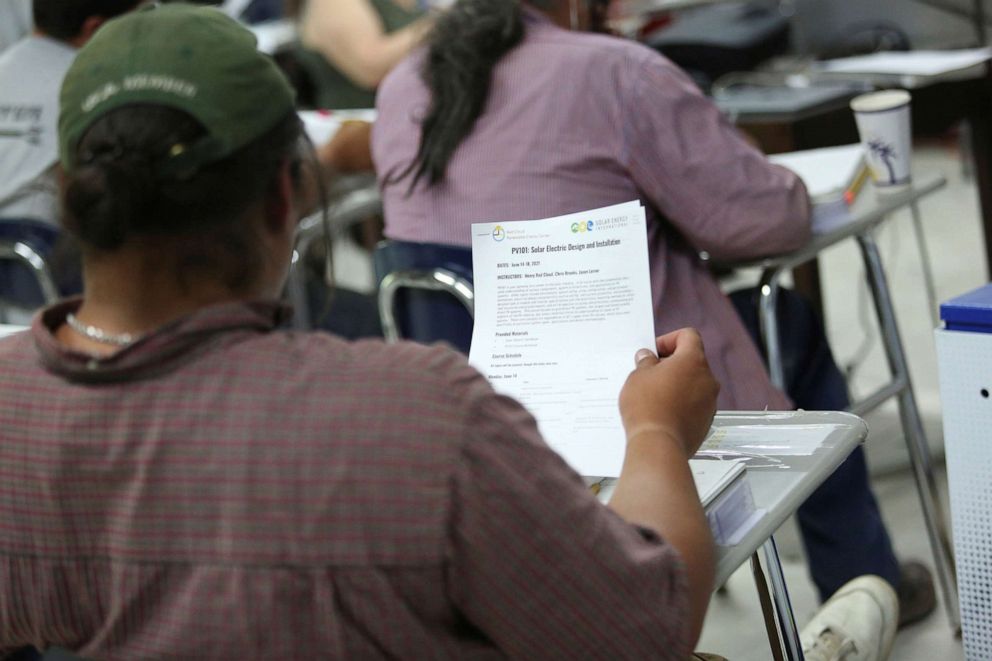 PHOTO: Student Gwe Gasco looks at a course handout on the Pine Ridge reservation in South Dakota, June 13, 2021. 