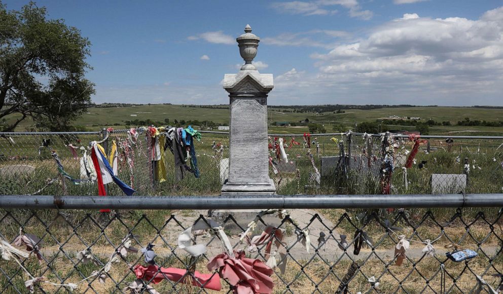 PHOTO: Ribbons and other tributes are tied to the Wounded Knee Massacre Memorial on the Pine Ridge reservation in South Dakota, June 18, 2021. 