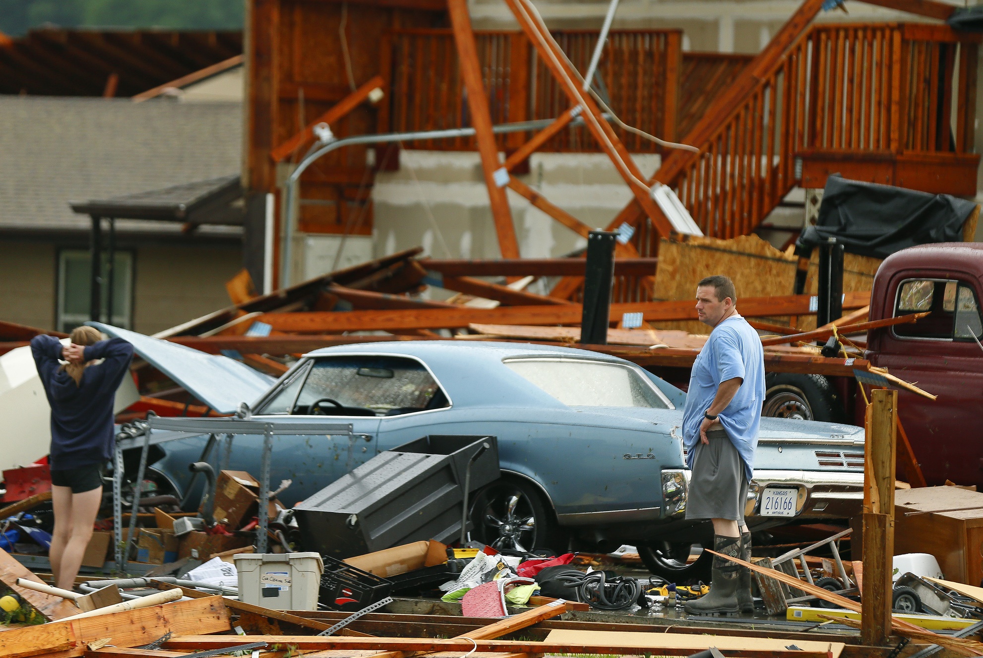 PHOTO: A man and woman inspect the damage to their home and classic cars after being hit by a tornado on Tuesday, May 28, 2019, in a neighborhood south of Lawrence, Kan., near US-59 highway and N. 1000 Road. 