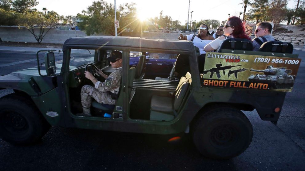 PHOTO: Tourists get a ride in a tour vehicle that also advertises gun range activities in Las Vegas, Oct. 2, 2017. 