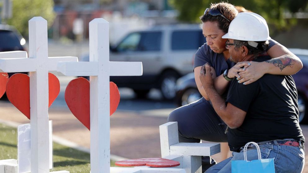 Ebony Saunders, left, hugs Greg Zanis in front of his memorial crosses, Oct. 5, 2017, in Las Vegas. 