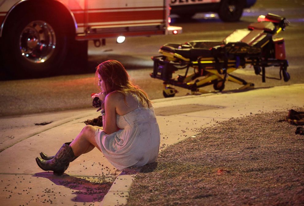 PHOTO: A woman sits on a curb at the scene of a shooting outside a music festival on the Las Vegas Strip, Oct. 2, 2017.