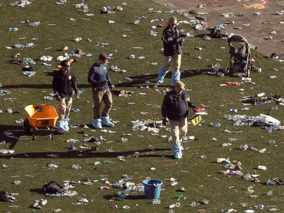 PHOTO: Investigators walk through debris on festival grounds across the street from the Mandalay Bay Resort and Casino, Oct. 3, 2017, in Las Vegas.