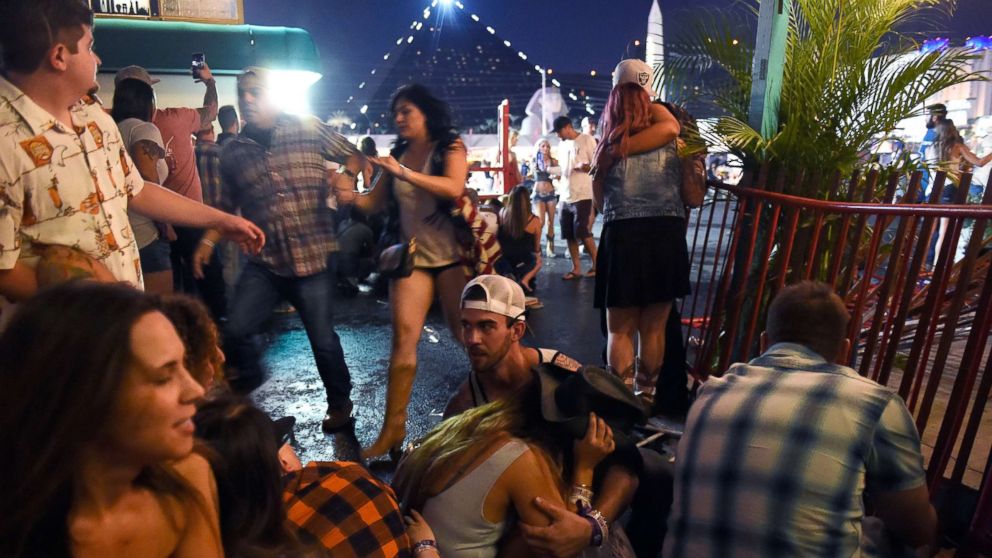 People run for cover at the Route 91 Harvest country music festival after gun fire was heard, Oct. 1, 2017 in Las Vegas. 