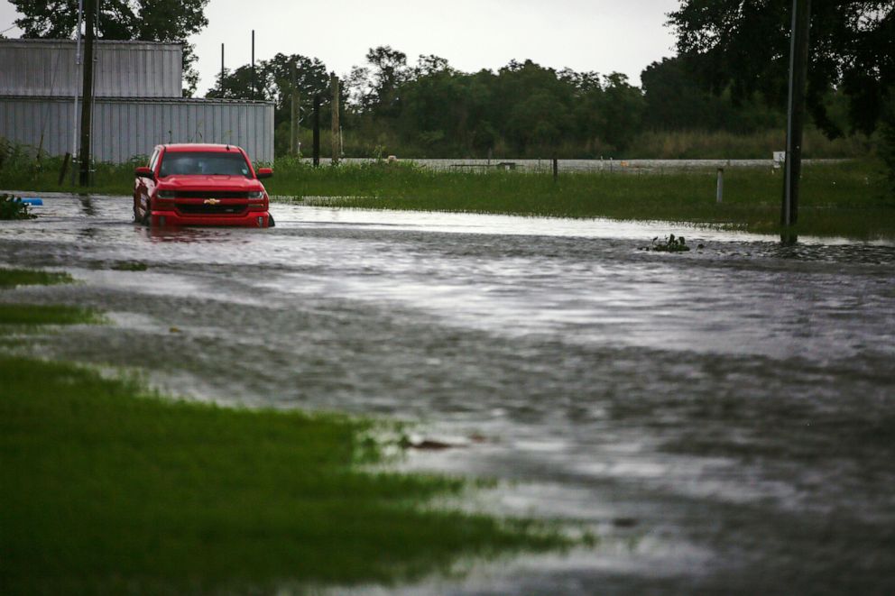 PHOTO: A car near Vermilion Bay drives through waters brought by Hurricane Laura approaching Abbeville, La., on Aug. 26, 2020.