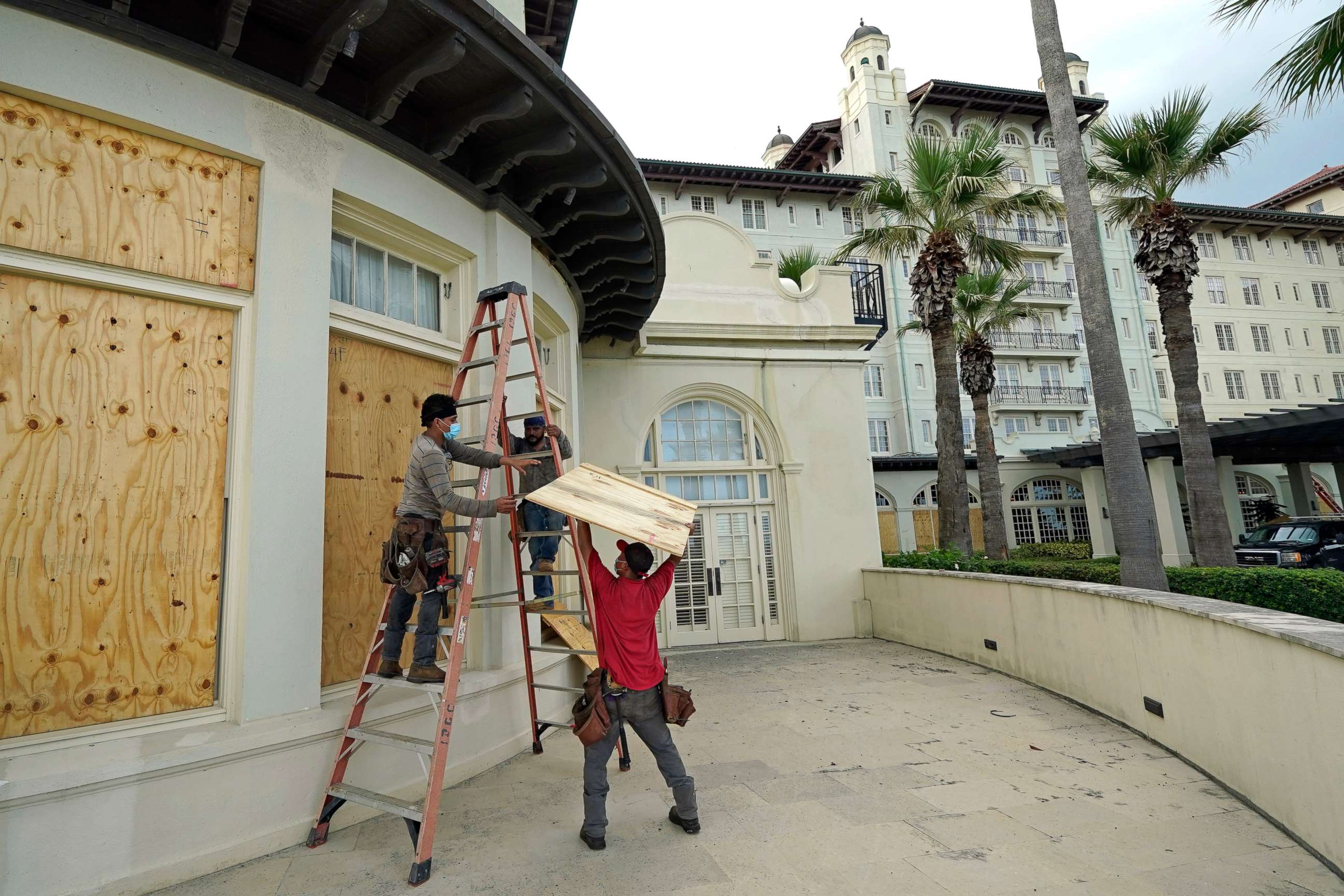 PHOTO: Workers board up windows at the Galvez Hotel & Spa, Tuesday, Aug. 25, 2020, in Galveston, Texas, as Hurricane Laura heads toward the Gulf Coast. 