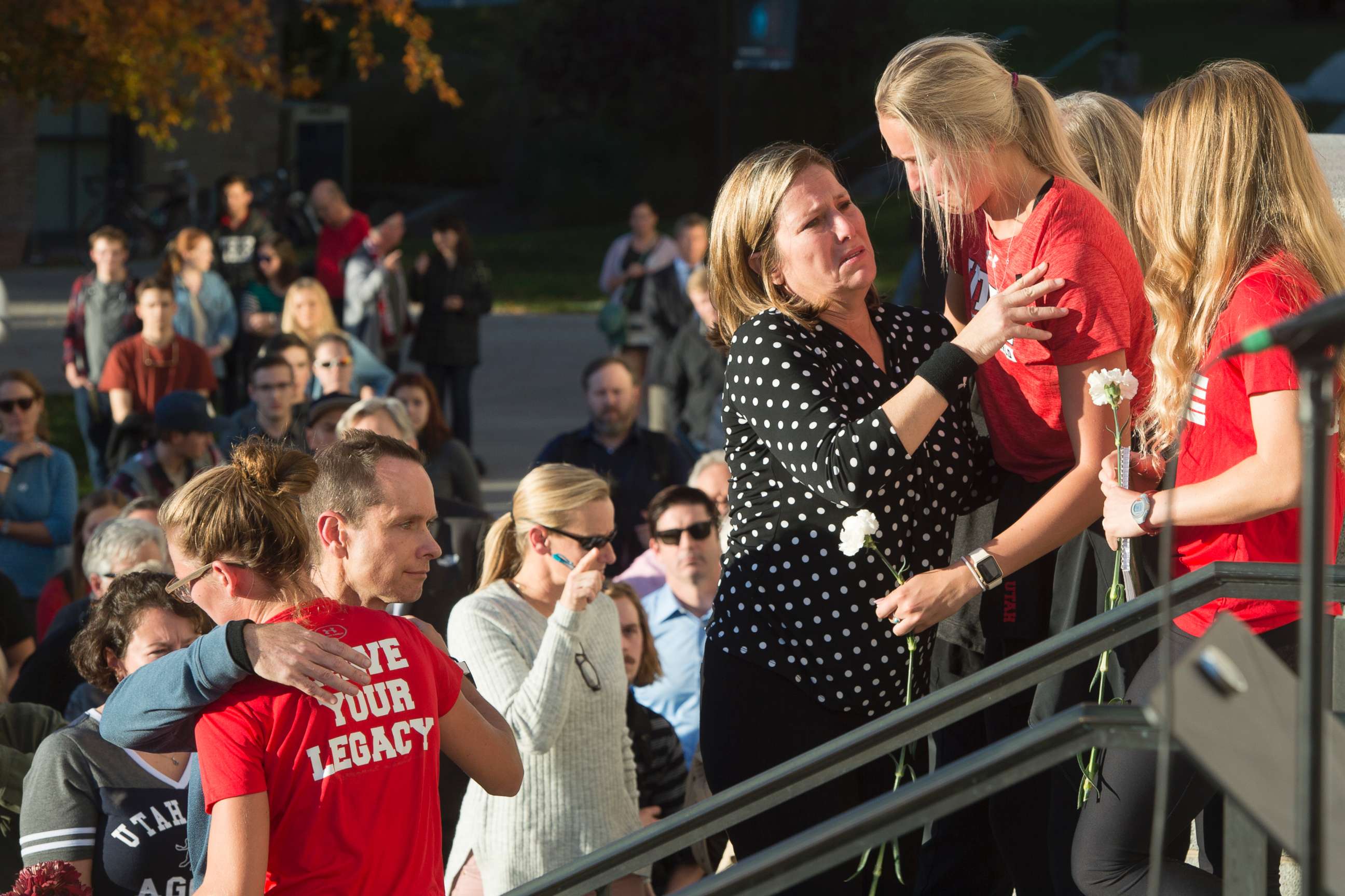 PHOTO: Lauren McCluskey's parents, Matt and Jill McCluskey, hug some of their daughter's teammates after a vigil for their daughter on Oct. 24, 2018 in Salt Lake City.