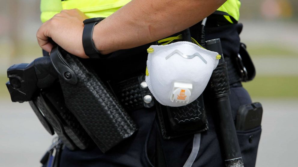 PHOTO: A North Charleston police officer carries a protective mask around his gun belt while working traffic at Roper St. Francis' North Charleston office, March 16, 2020, in North Charleston, S.C.
