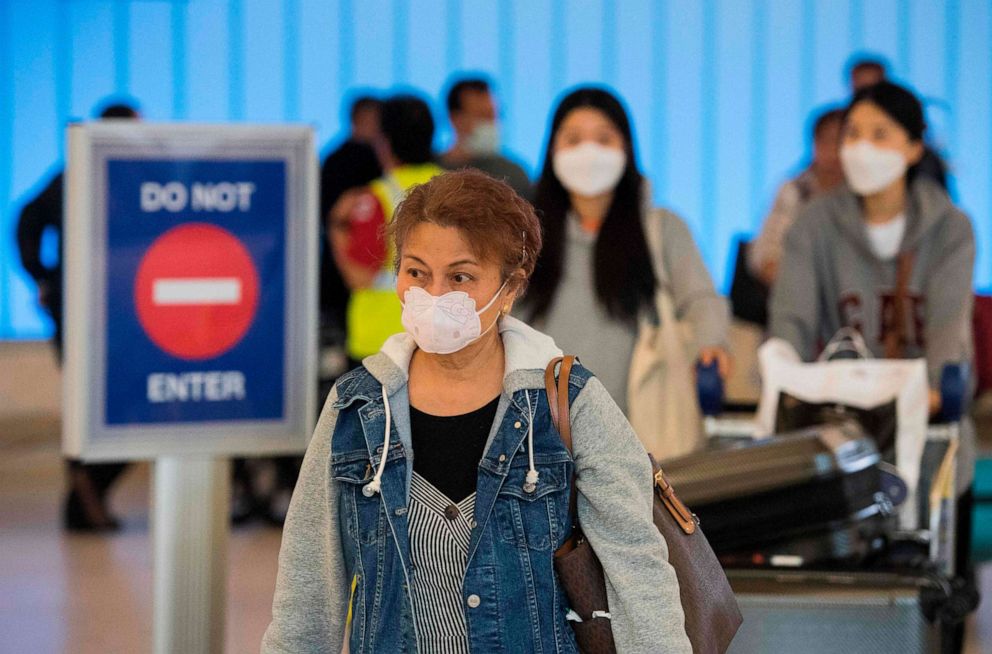 PHOTO: Passengers wear face masks to protect against the spread of the novel coronavirus, as they arrive at Los Angeles International Airport (LAX) in Los Angeles, California, on Feb. 29, 2020. 