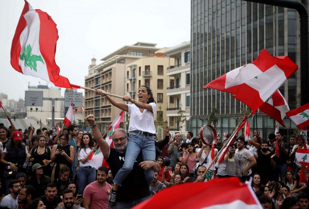 PHOTO: Lebanese protesters wave national flags during an anti-government demonstration in the centre of the capital Beirut, Oct. 26, 2019.