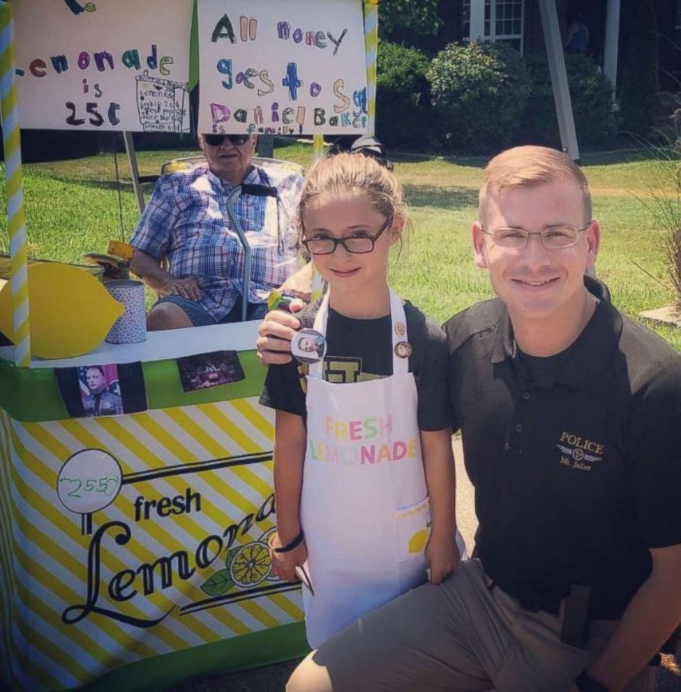PHOTO: Caroline Freeman set up a lemonade stand Saturday to raise money for the wife and young daughter of Sgt. Daniel Baker, who was killed in the line of duty on May 30. Freeman is seen here with Police Captain Tyler Chandler. 