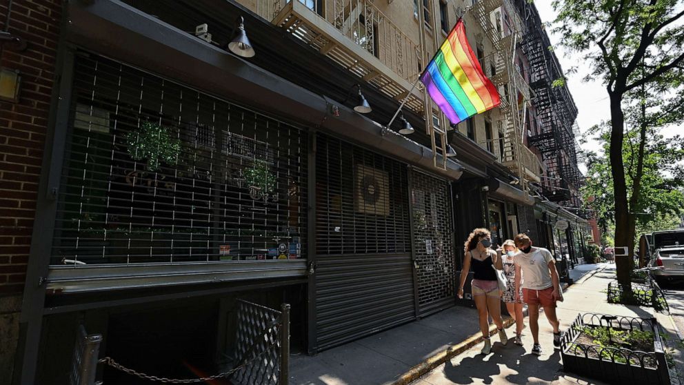 PHOTO: People walk past a temporarily closed Ty's Bar NYC on Christopher Street in the West Village, June 23, 2020, in New York.