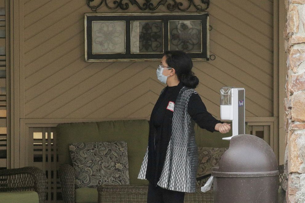 PHOTO: A woman uses a hand sanitizer dispenser at the Life Care Center of Kirkland, the long-term care facility linked to several confirmed coronavirus cases in the state, in Kirkland, Washington, March 4, 2020.