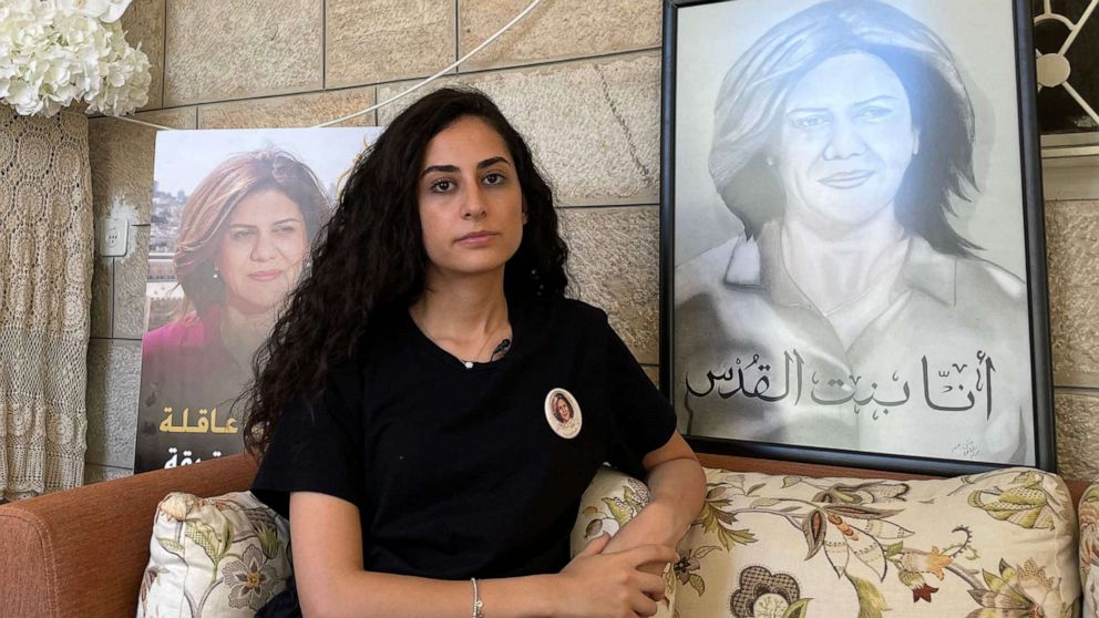 PHOTO: Lina Abu Akleh, the niece of slain Al Jazeera journalist Shireen Abu Akleh, sits surrounded by photographs of her late aunt, at the family home in occupied east Jerusalem, on July 13, 2022.