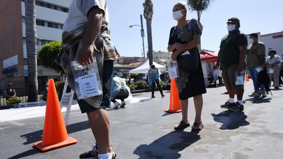 PHOTO: People wait in line at a walk-up COVID-19 testing location in Los Angeles, California, on August 10, 2020.