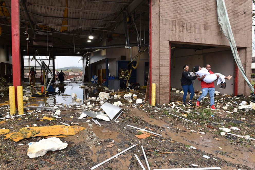 PHOTO: A woman is carried out of a fire station to an ambulance after a tornado tore through west Little Rock, Ark., on March 31, 2023.