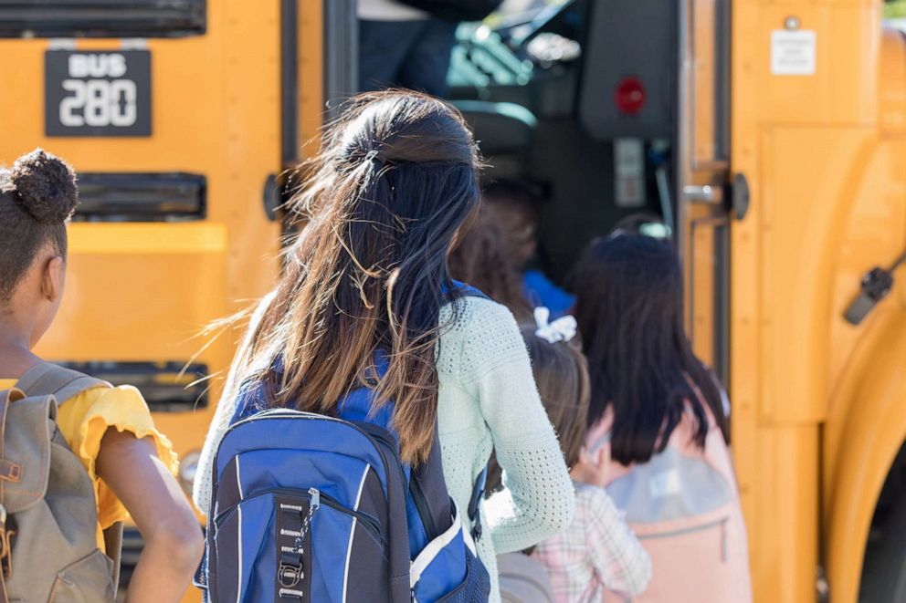 PHOTO: A line of school children with board a school bus in an undated stock image.