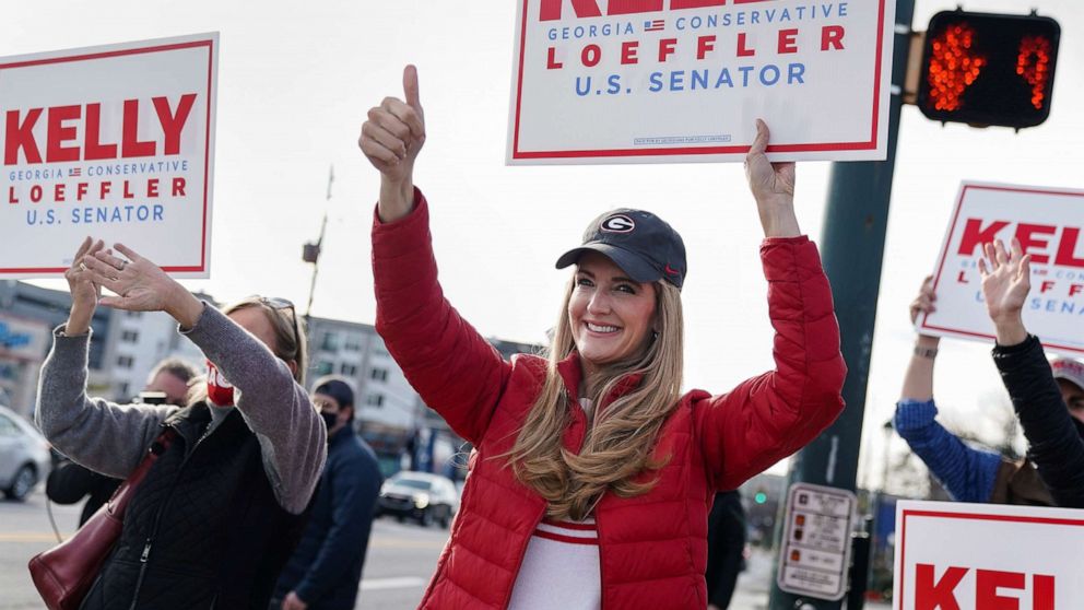 PHOTO: Senator Kelly Loeffler waves a campaign sign with supporters outside Sandy Springs City Hall, Jan. 5, 2021, as voters head to the polls, in Sandy Springs, Ga.