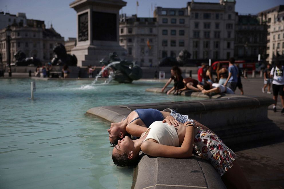 PHOTO: Two women dip their heads into the fountain in Trafalgar Square to cool off on July 19, 2022 in London.