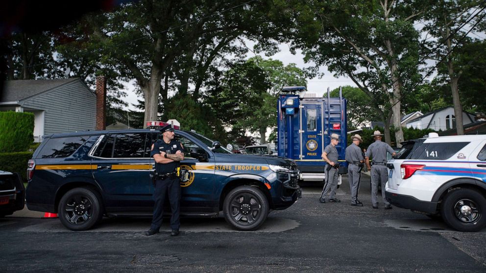 PHOTO: Police officers stand guard near the house where a suspect has been taken into custody on New York's Long Island in connection with a long-unsolved string of killings, July 14, 2023, in Massapequa, New York.