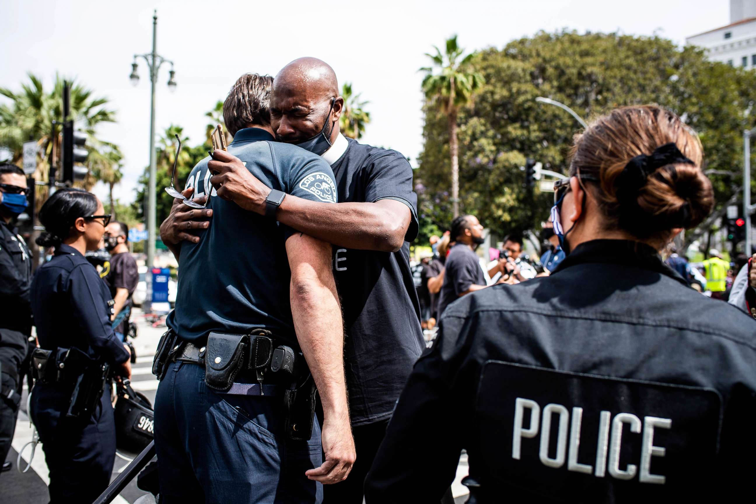 PHOTO: Pastor Calvin Sparks, of Life Pavilion in Carson, hugs LAPD officers after some officers took a knee with clergy and marchers at LAPD Headquarters during a demonstration demanding justice for George Floyd, June 2, 2020 in Los Angeles.