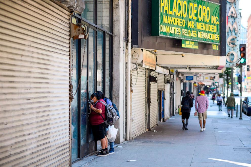 PHOTO: Two women peer into a closed store in downtown Los Angeles during the coronavirus COVID-19 pandemic on April 14, 2020.