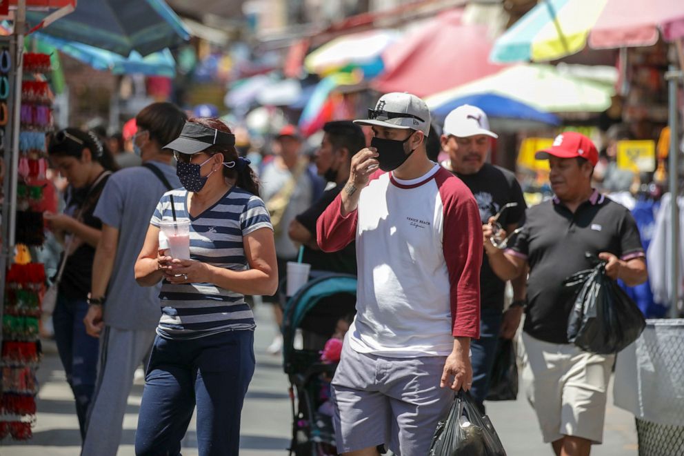 PHOTO: People shop in mask and without masks in a very congested market Santee Alley on July 14, 2022, in Los Angeles.