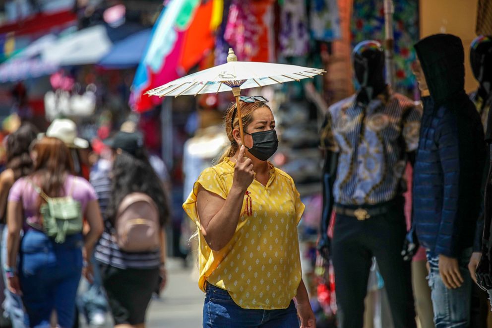 PHOTO: People shop in masks and without masks in a very congested market Santee Alley on July 14, 2022, in Los Angeles.